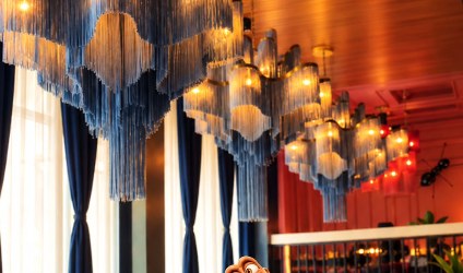 Cascading blue chandeliers over velvet booths at Flying Saucer