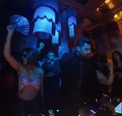 Guests dancing under blue-lit chandeliers at a Flying Saucer night